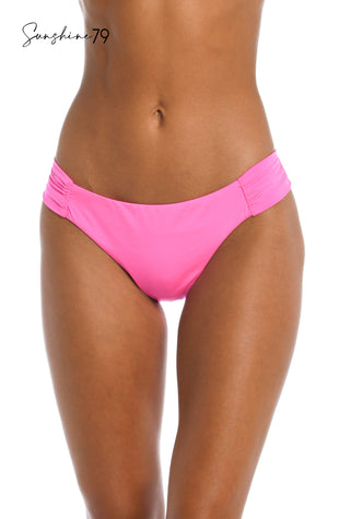 Model is wearing a solid hot pink side shirred bikini bottom from our Sunshine 79 brand.