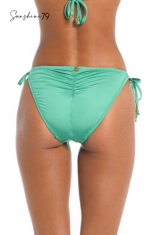 Model is wearing a solid seagreen colored string tie side hipster bikini bottom from our Sunshine 79 brand.