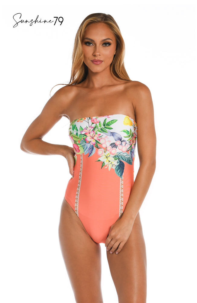 
            
                Load image into Gallery viewer, Model is wearing a coral multicolored floral printed bandeau one piece from our Sunshine 79 brand.
            
        