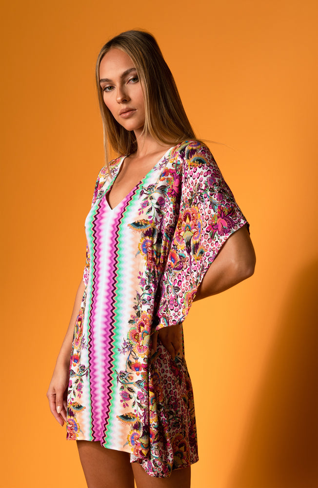 
            
                Load image into Gallery viewer, Model is wearing a pink multicolored floral and striped printed v neck caftan cover up from our Sunshine 79 brand.
            
        