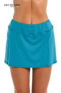 Model is wearing a solid teal colored swim skort bottom from our 24th & Ocean brand.