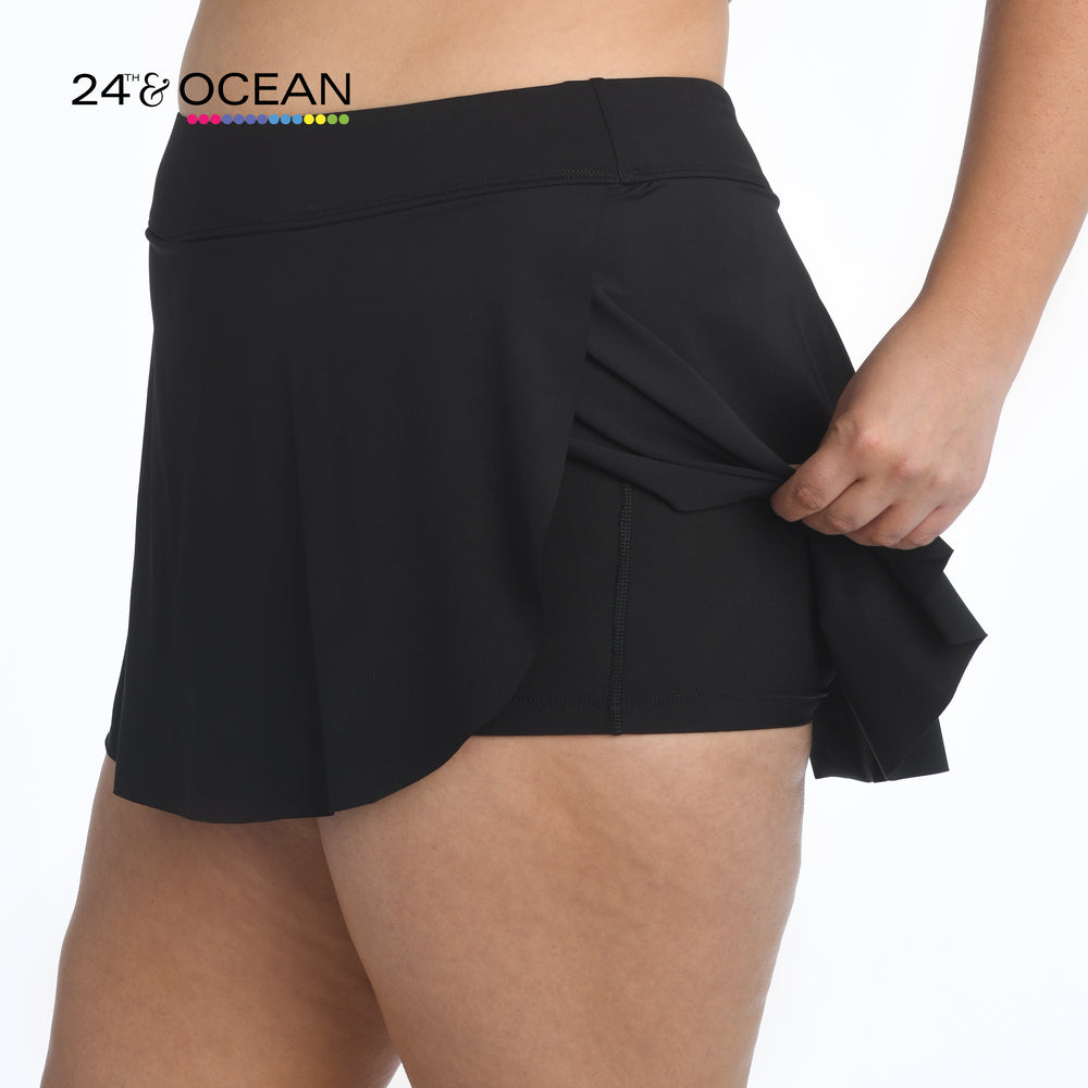 Model is wearing a solid black colored petal skort swim bottom from our 24th & Ocean brand.