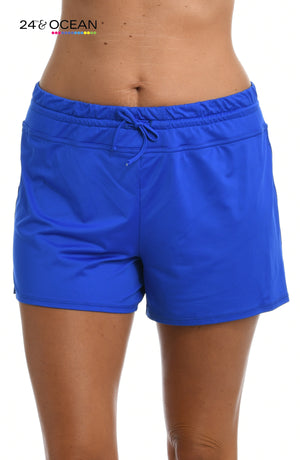 Model is wearing a solid sapphire blue colored swim short bottom from our 24th & Ocean brand.