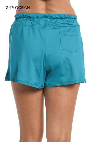 
            
                Load image into Gallery viewer, Model is wearing a solid teal colored swim short bottom from our 24th &amp;amp; Ocean brand.
            
        