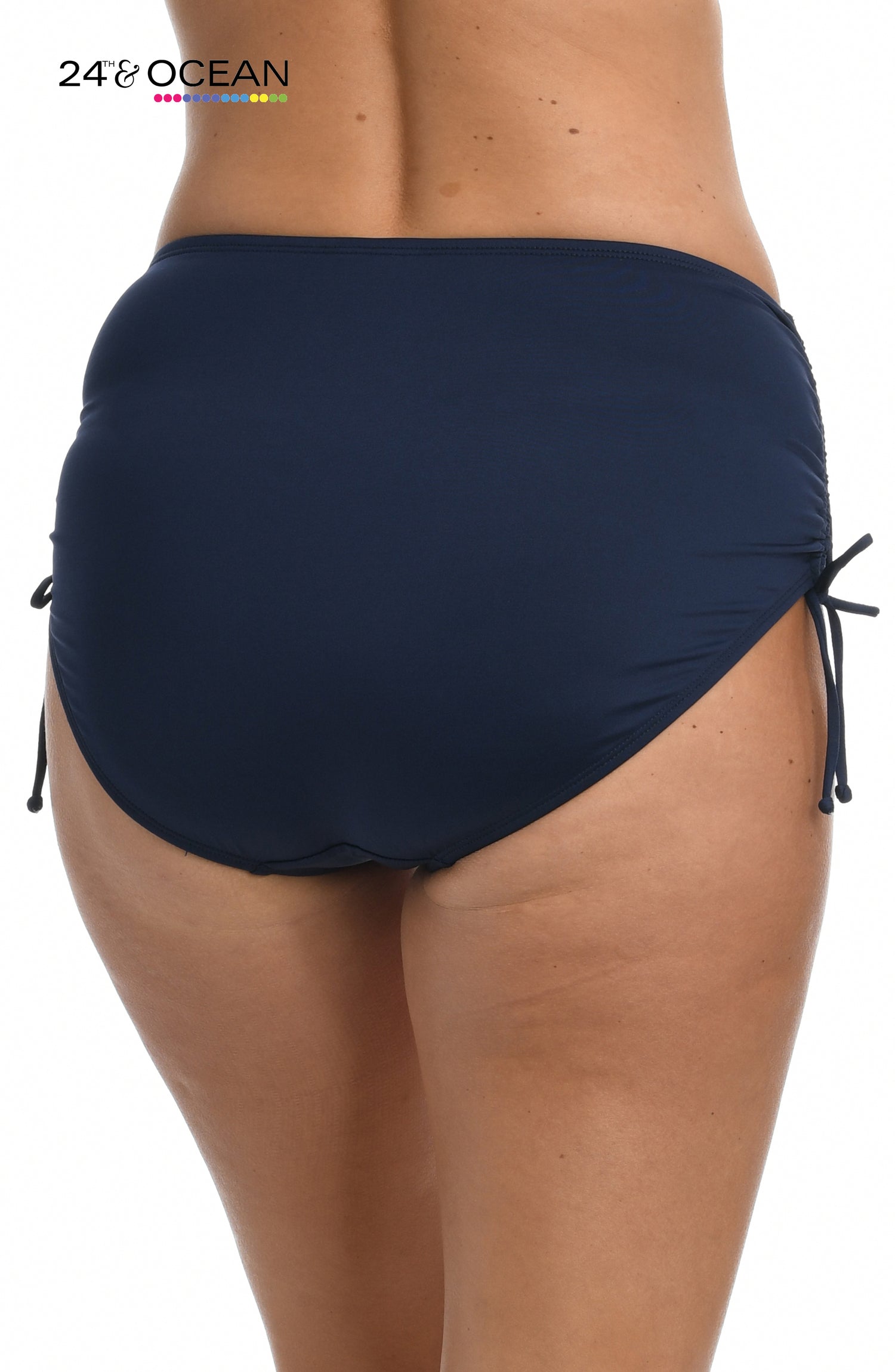 Model is wearing a solid midnight blue colored mid waist adjustable hipster bikini bottom from our 24th & Ocean brand.