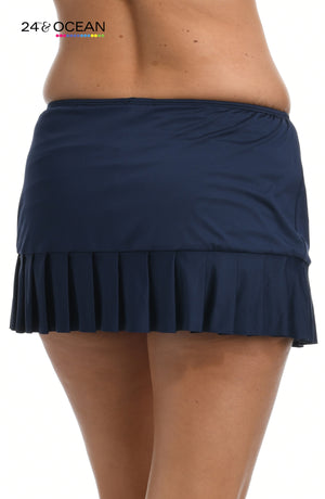 Model is wearing a solid midnight blue colored mid waist pleated skirted bottom from our 24th & Ocean brand.
