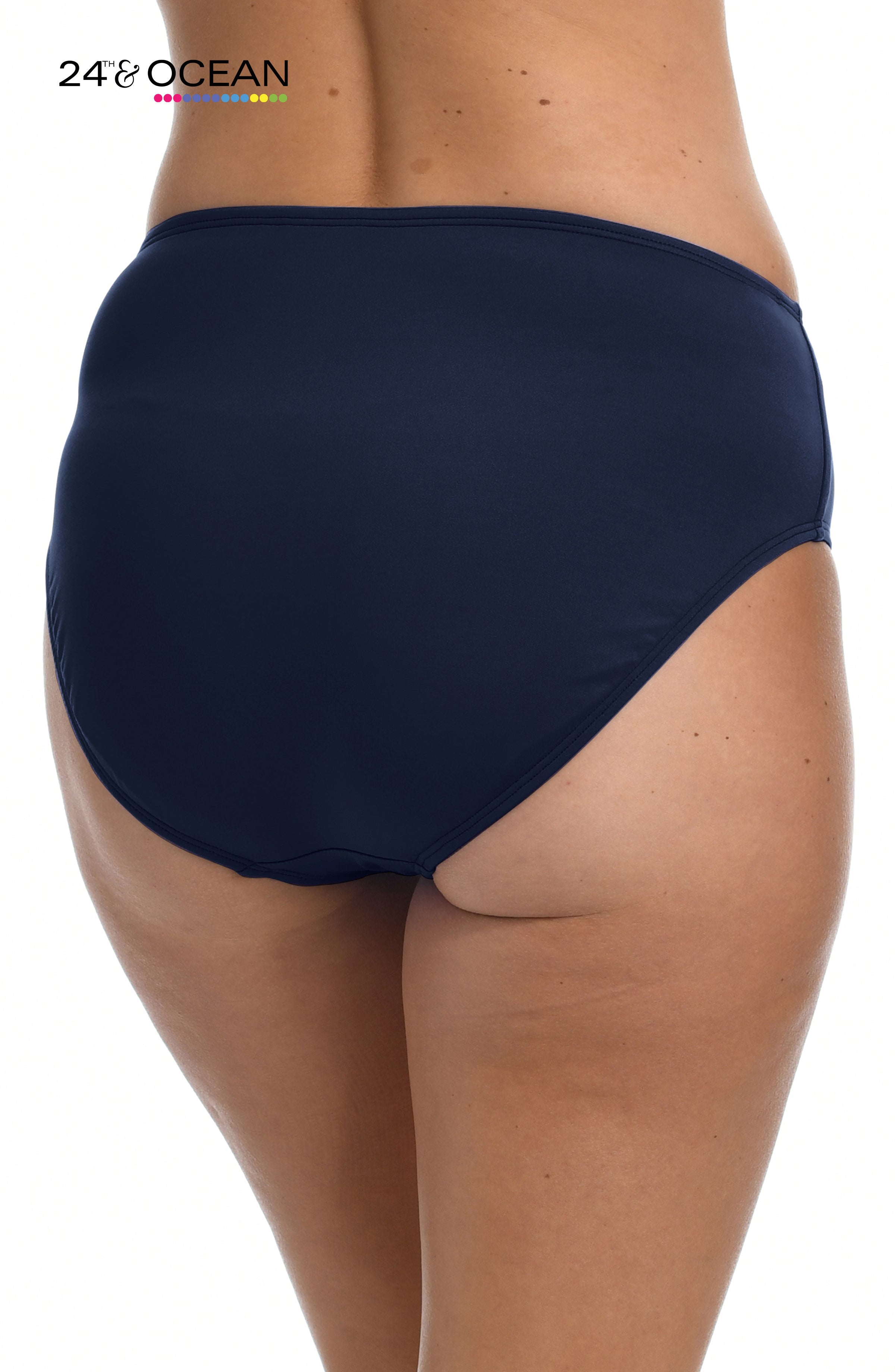 Model is wearing a solid midnight blue colored mid waist hipster bikini bottom from our 24th & Ocean brand.