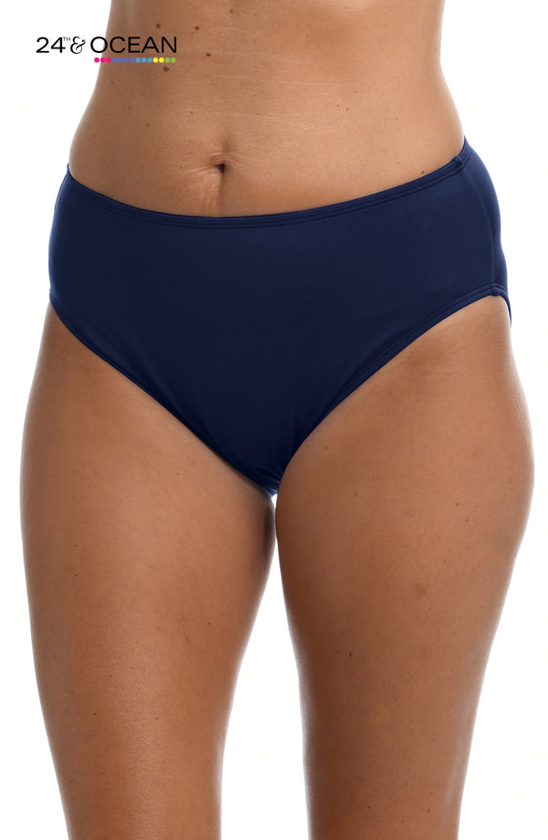 Model is wearing a solid midnight blue colored mid waist hipster bikini bottom from our 24th & Ocean brand.