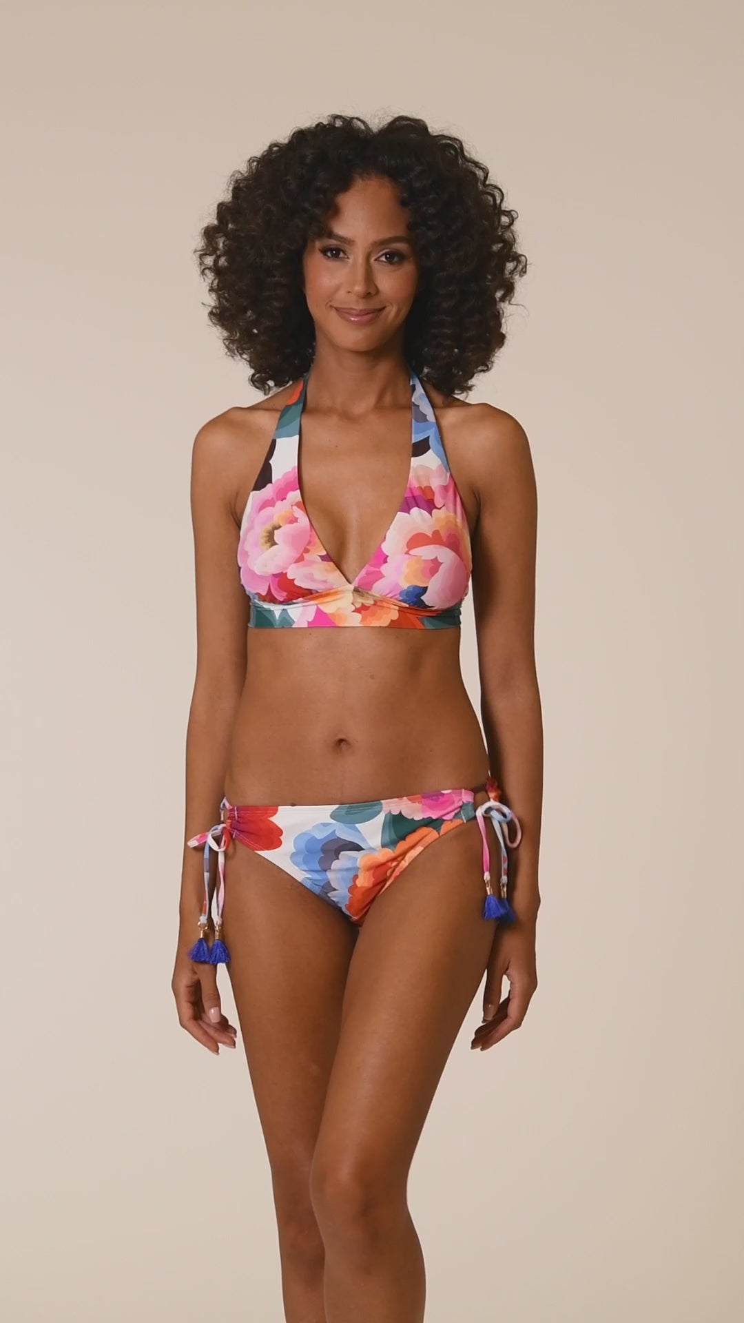 This is a video of a Model is wearing a multi colored floral printed banded halter triangle top from our Floral Rhythm collection!